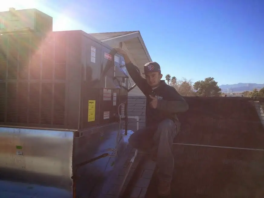 HVAC technician performing AC Tune-Up on a rooftop unit in Tampa